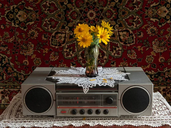 Retro odtwarzacz muzyki i radio na drewnianym stole wazon z kwiatami — Zdjęcie stockowe