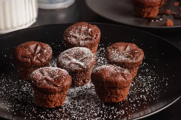 Muffins de chocolate atmosférico escuro em um fundo preto — Fotografia de Stock