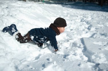 Kışın karda oynarken küçük çocuk