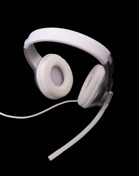White headphones with a microphone for playing on a black background — Stock Photo, Image
