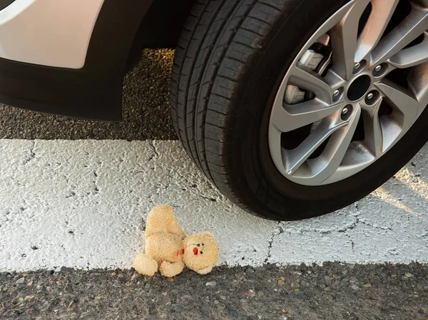 Stoffbär im Blut unter den Autorädern — Stockfoto