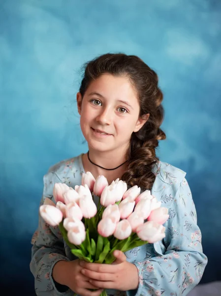 Retrato de uma linda menina em um fundo azul — Fotografia de Stock