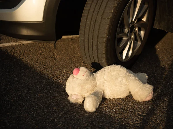 Orso giocattolo morbido nel sangue sotto le ruote dell'auto — Foto Stock