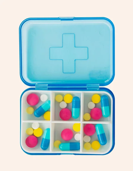 Beyaz arka plan üzerinde izole birçok gün için mavi plastik makinelinin birçok renk hap kümesi.
