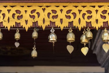 Saçak Tayland Tapınağı'nda asılı altın dua eden çan.