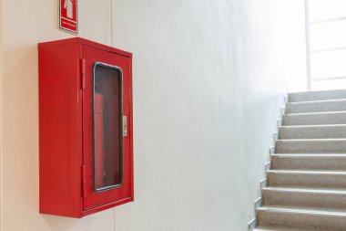 Yangın söndürücü güvenlik oluşturmak için merdiven yakınındaki beyaz duvar kabine.