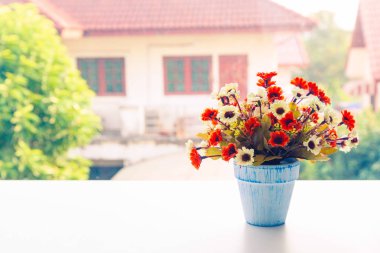 Ev ve gr ile masada vazo renkli yapay çiçekler