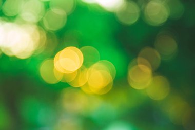 Gün batımında yeşil arka planda yuvarlak ışık bokeh soyut bulanık resim