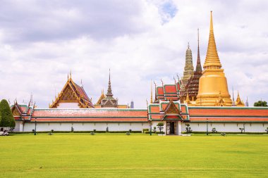 Wat Phra Kaew 'deki güzel manzara, Zümrüt Buda Tapınağı gökyüzündeki bulutlara karşı ve yeşil bir çimenliğe karşı