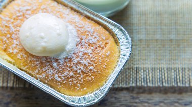 Yüksek açılı görüntüler, bir fincan Hokkaido sütlü ekmeği kapatıyorlar. Sabah bir fincan sütle ahşap bir masanın üzerinde krema ile..