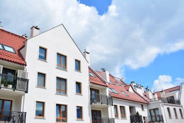 Mavi gökyüzü olan güneşli bir günde modern apartman binaları. Modern bir apartmanın cephesi