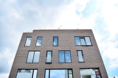 Mavi gökyüzü olan güneşli bir günde modern apartman binaları. Modern bir apartmanın cephesi