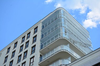 Mavi gökyüzü olan güneşli bir günde modern apartman binaları. Modern bir apartmanın cephesi