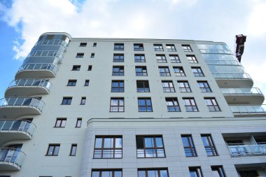 Mavi gökyüzü olan güneşli bir günde modern apartman binaları. Modern bir apartmanın cephesi