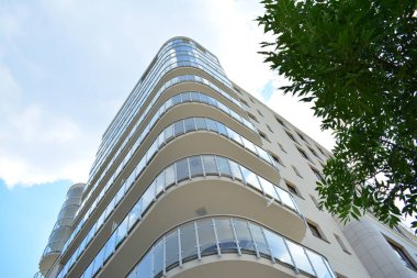 Mavi gökyüzü olan güneşli bir günde modern apartman binaları. Modern bir apartmanın cephesi