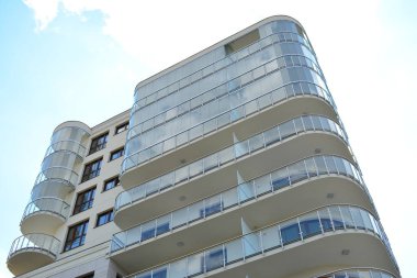 Mavi gökyüzü olan güneşli bir günde modern apartman binaları. Modern bir apartmanın cephesi
