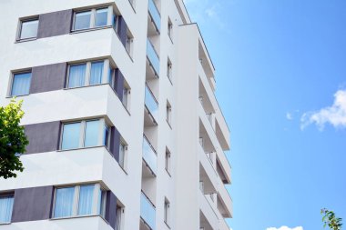 Mavi gökyüzü olan güneşli bir günde modern apartman binaları. Modern bir apartmanın cephesi