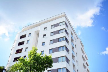 Mavi gökyüzü olan güneşli bir günde modern apartman binaları. Modern bir apartmanın cephesi