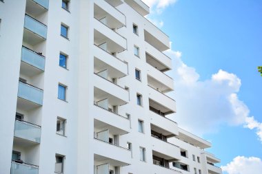 Mavi gökyüzü olan güneşli bir günde modern apartman binaları. Modern bir apartmanın cephesi