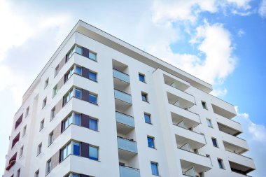 Mavi gökyüzü olan güneşli bir günde modern apartman binaları. Modern bir apartmanın cephesi