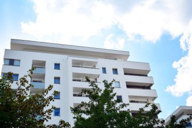 Mavi gökyüzü olan güneşli bir günde modern apartman binaları. Modern bir apartmanın cephesi