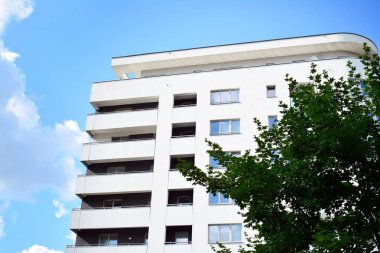 Mavi gökyüzü olan güneşli bir günde modern apartman binaları. Modern bir apartmanın cephesi