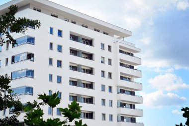 Mavi gökyüzü olan güneşli bir günde modern apartman binaları. Modern bir apartmanın cephesi