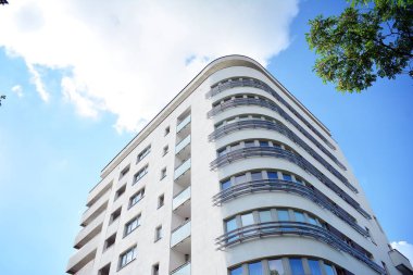 Mavi gökyüzü olan güneşli bir günde modern apartman binaları. Modern bir apartmanın cephesi