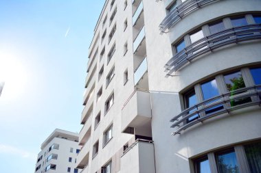 Mavi gökyüzü olan güneşli bir günde modern apartman binaları. Modern bir apartmanın cephesi