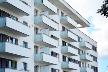 Mavi gökyüzü olan güneşli bir günde modern apartman binaları. Modern bir apartmanın cephesi