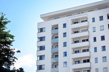 Mavi gökyüzü olan güneşli bir günde modern apartman binaları. Modern bir apartmanın cephesi