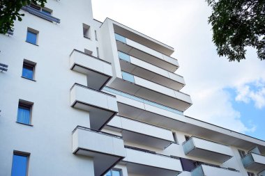 Mavi gökyüzü olan güneşli bir günde modern apartman binaları. Modern bir apartmanın cephesi