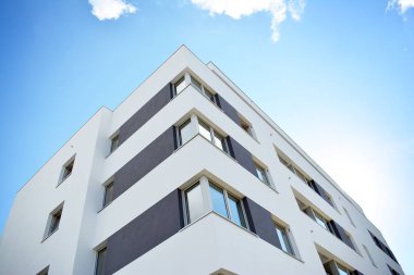 Mavi gökyüzü olan güneşli bir günde modern apartman binaları. Modern bir apartmanın cephesi