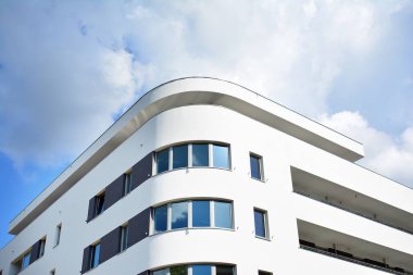 Mavi gökyüzü olan güneşli bir günde modern apartman binaları. Modern bir apartmanın cephesi