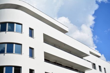 Mavi gökyüzü olan güneşli bir günde modern apartman binaları. Modern bir apartmanın cephesi