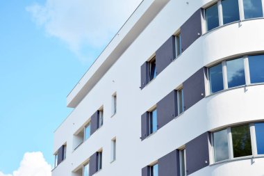 Mavi gökyüzü olan güneşli bir günde modern apartman binaları. Modern bir apartmanın cephesi