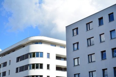 Mavi gökyüzü olan güneşli bir günde modern apartman binaları. Modern bir apartmanın cephesi