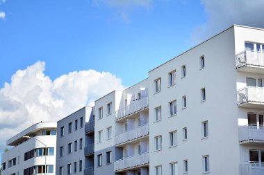 Mavi gökyüzü olan güneşli bir günde modern apartman binaları. Modern bir apartmanın cephesi
