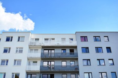 Mavi gökyüzü olan güneşli bir günde modern apartman binaları. Modern bir apartmanın cephesi