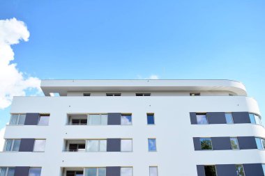 Mavi gökyüzü olan güneşli bir günde modern apartman binaları. Modern bir apartmanın cephesi
