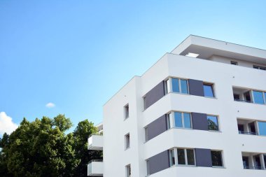 Mavi gökyüzü olan güneşli bir günde modern apartman binaları. Modern bir apartmanın cephesi