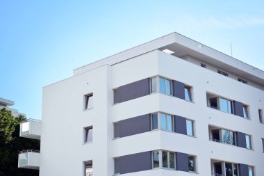 Mavi gökyüzü olan güneşli bir günde modern apartman binaları. Modern bir apartmanın cephesi
