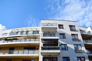 Mavi gökyüzü olan güneşli bir günde modern apartman binaları. Modern bir apartmanın cephesi