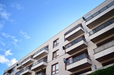 Mavi gökyüzü olan güneşli bir günde modern apartman binaları. Modern bir apartmanın cephesi