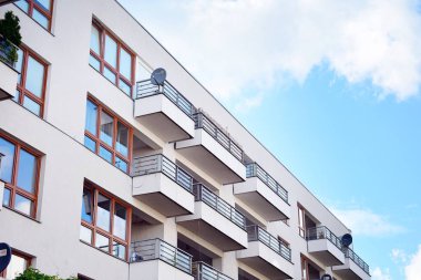 Mavi gökyüzü olan güneşli bir günde modern apartman binaları. Modern bir apartmanın cephesi