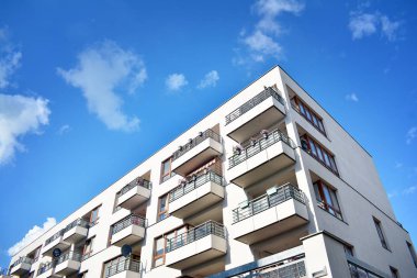 Mavi gökyüzü olan güneşli bir günde modern apartman binaları. Modern bir apartmanın cephesi