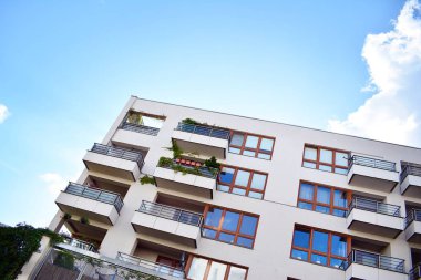 Mavi gökyüzü olan güneşli bir günde modern apartman binaları. Modern bir apartmanın cephesi