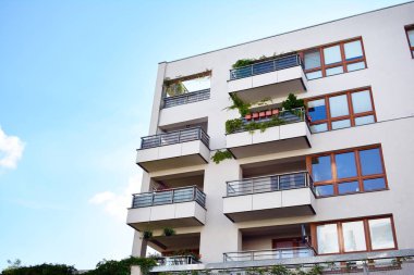 Mavi gökyüzü olan güneşli bir günde modern apartman binaları. Modern bir apartmanın cephesi