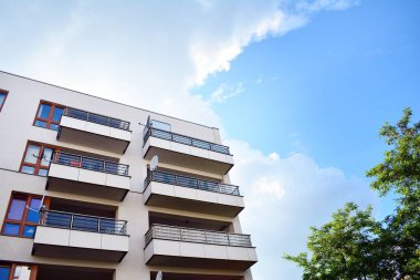 Mavi gökyüzü olan güneşli bir günde modern apartman binaları. Modern bir apartmanın cephesi
