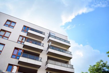 Mavi gökyüzü olan güneşli bir günde modern apartman binaları. Modern bir apartmanın cephesi